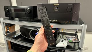 Marantz Cinema 30 AVR on AV rack with projector below and remote control in hand