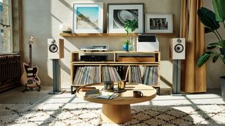 Bowers & Wilkins 606 S3 speakers on stands either side of a console bearing a record player and shelves of vinyl